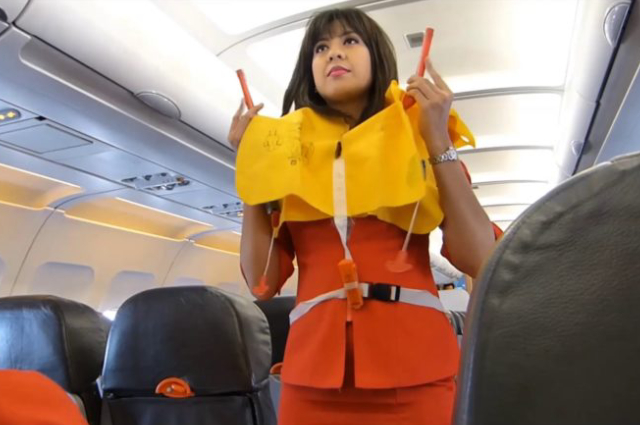Image showing an air hostess guiding the flight passengers about safety measures.